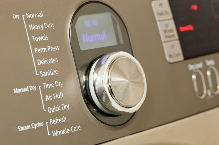 Close-up of a clothes dryer control panel with a large rotary dial, drying options, and a digital screen showing "00:46 Normal".